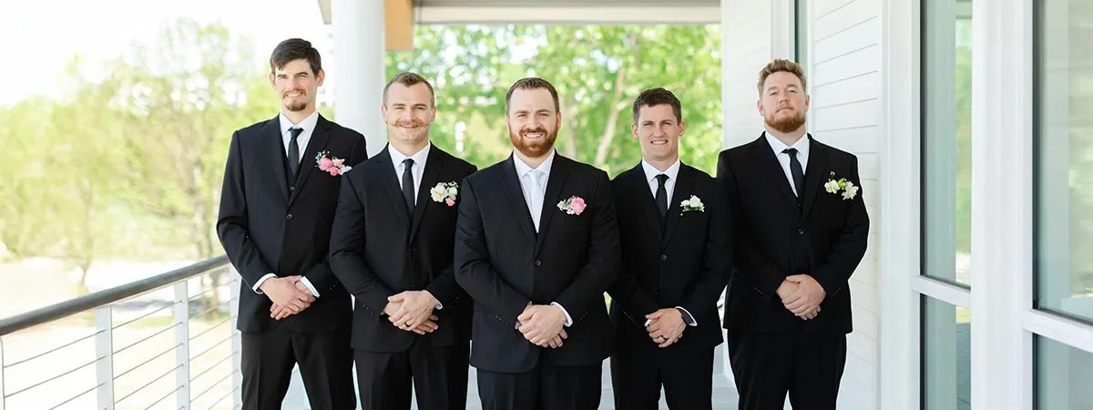 Group of groomsmen celebrating at a wedding